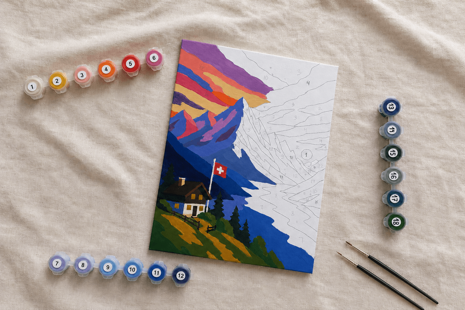 Partially painted Swiss mountain canvas with numbered paint pots and two brushes